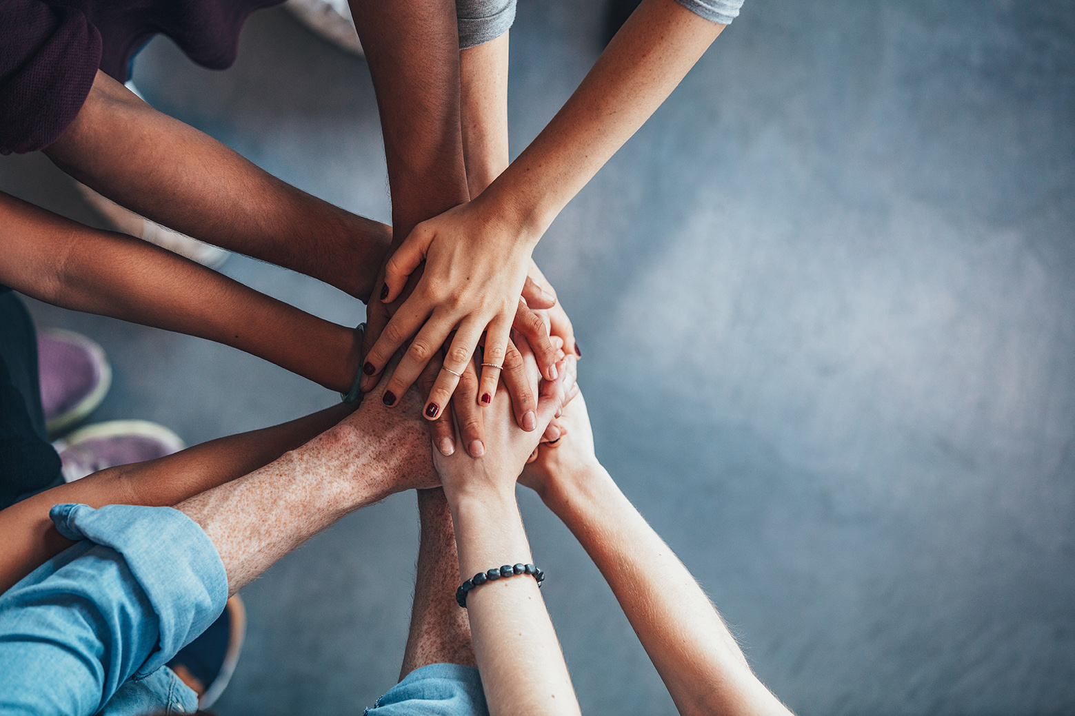 5 Key Differences in Credit Unions vs. Banks. Stack of hands showing unity and teamwork