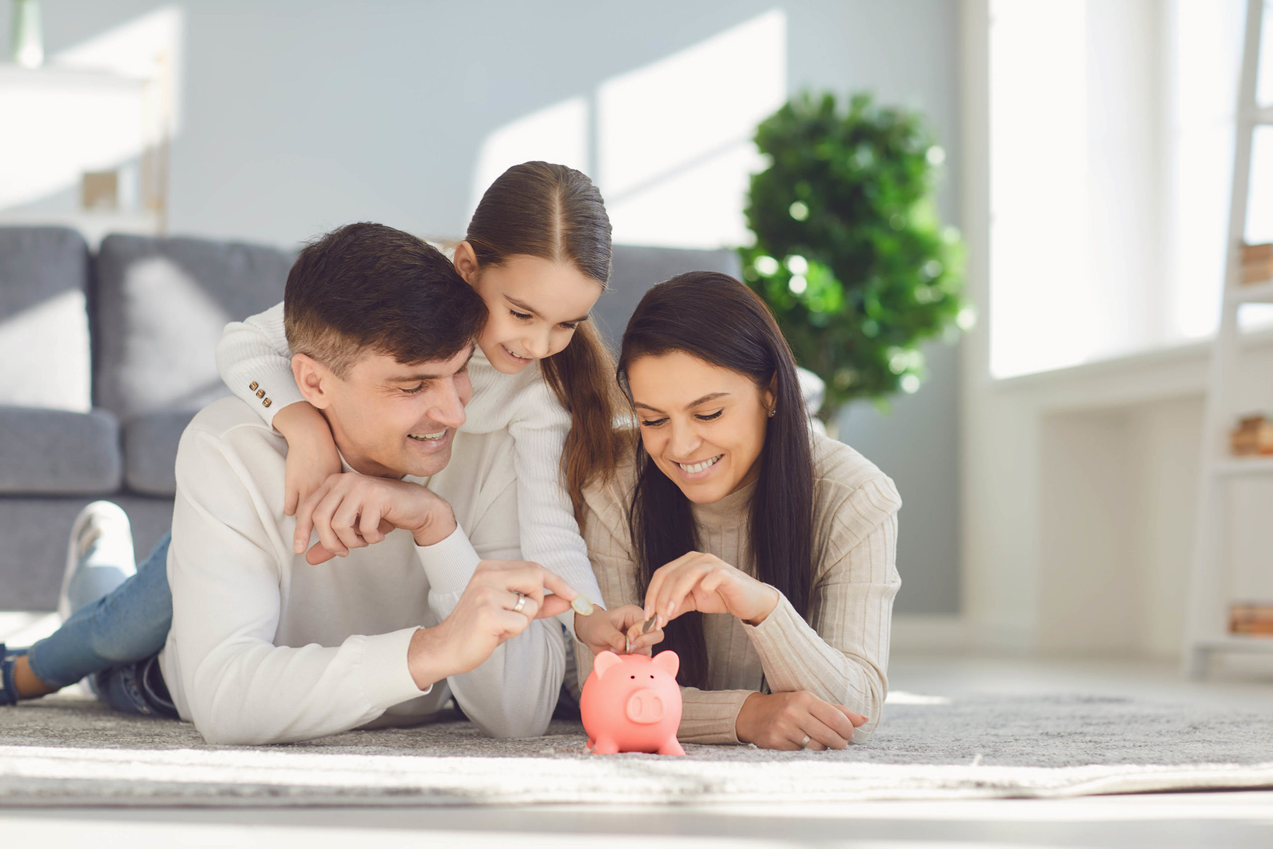 Happy family saves money in a piggy bank pig.